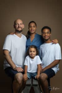 Belle photo de famille entres les parents et la fratrie durant une séance photo au Studio Tony Rapiteau